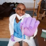 Smiling black male nurse administers covid test.